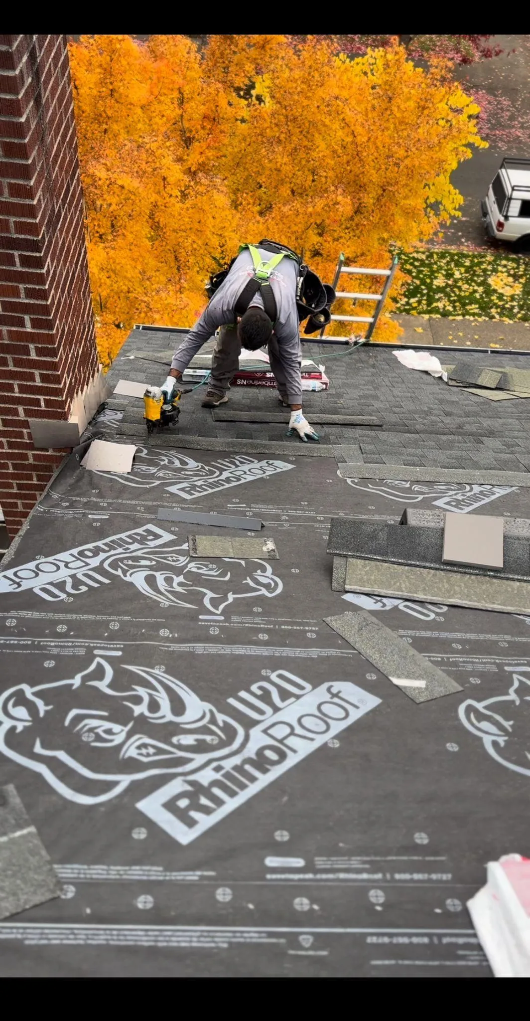 Worker installing roofing material on a house roof